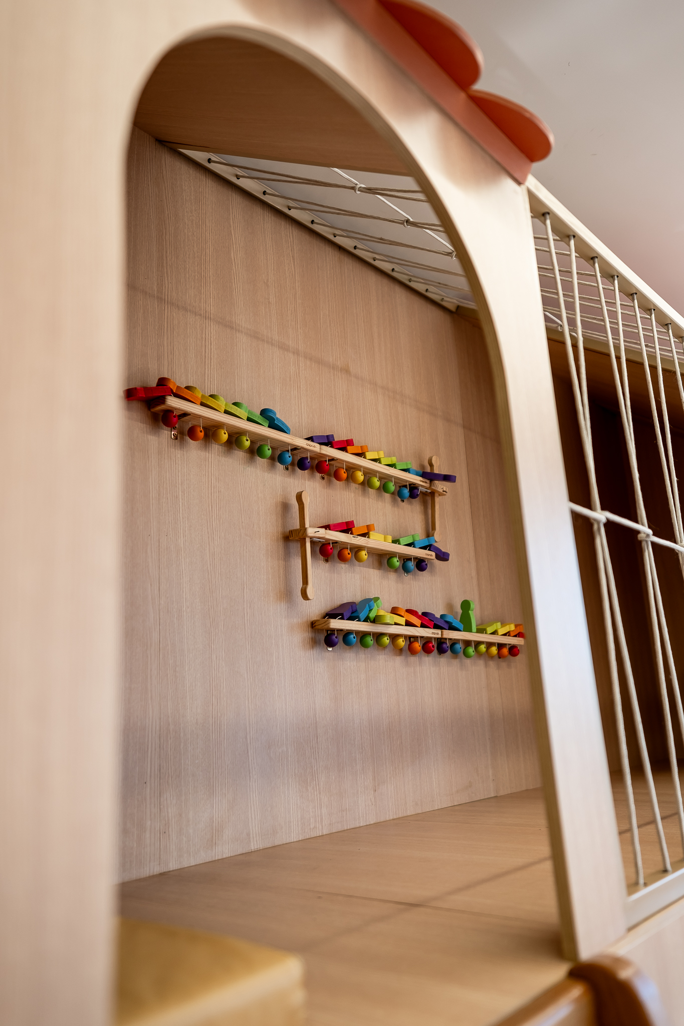 Detalhe de brinquedos de madeira coloridos pendurados na parede